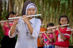 Burmese Sister Stella Pie Pi Moe teaches children to play the flute in a class at St. Mary's Catholic Church in the Ban Mai Nai Soi refugee camp in Thailand. Sister Stella is assigned to the camp--home to thousands of Burmese refugees--by the diocese of Loikaw in Myanmar. The flutes are cut from common PVC pipe.
